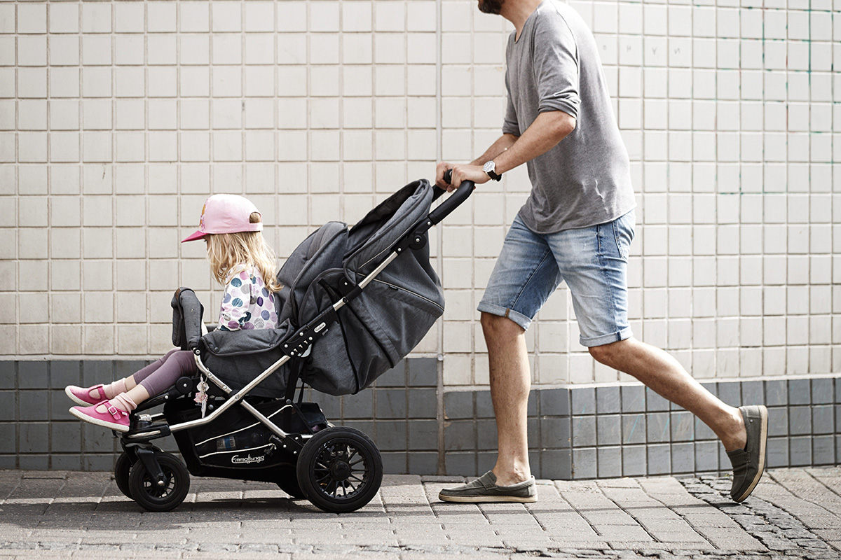 Isä ja rattaissa istuva lapsi